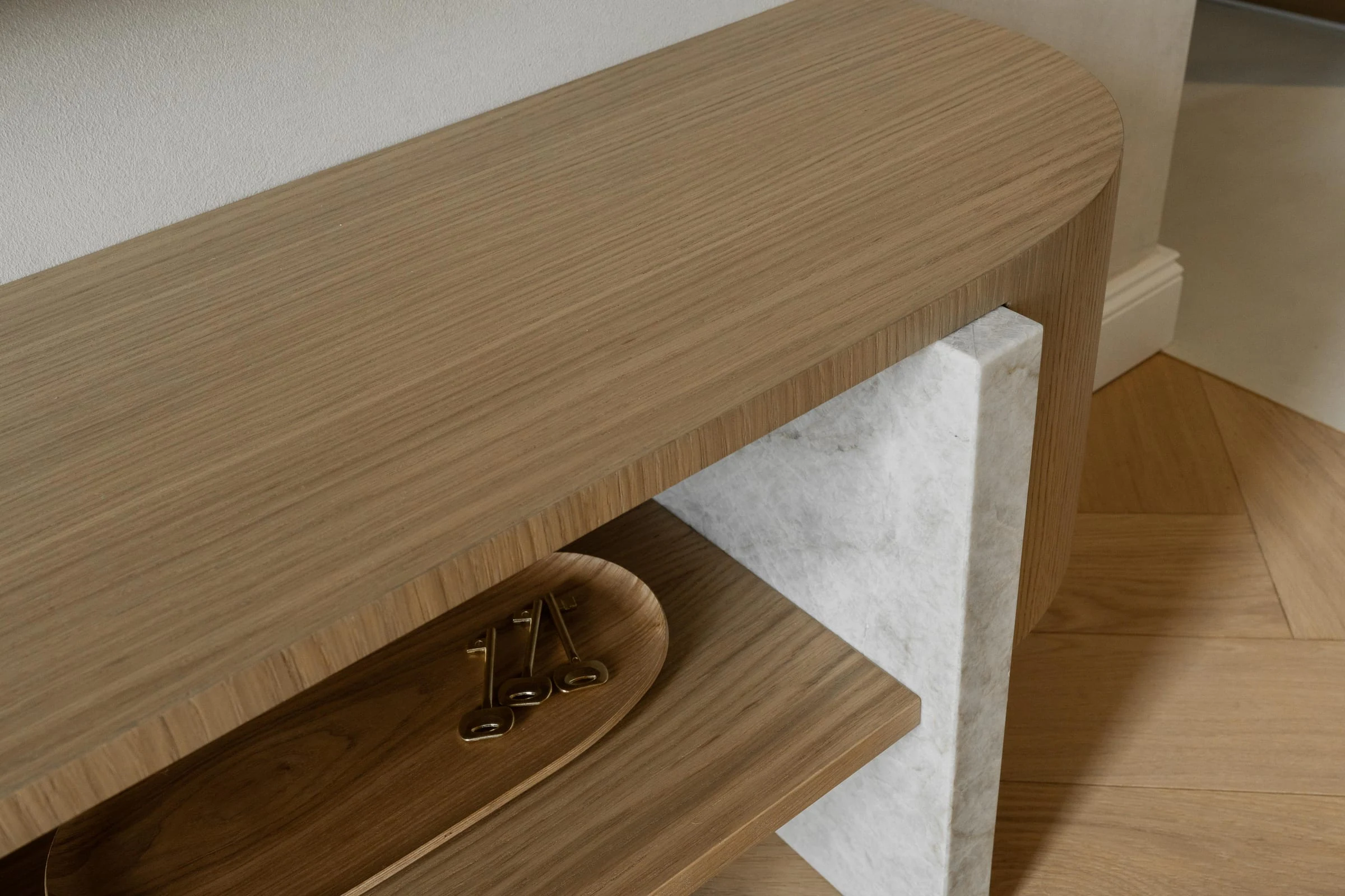 Rounded bespoke oak console with a pale stone support