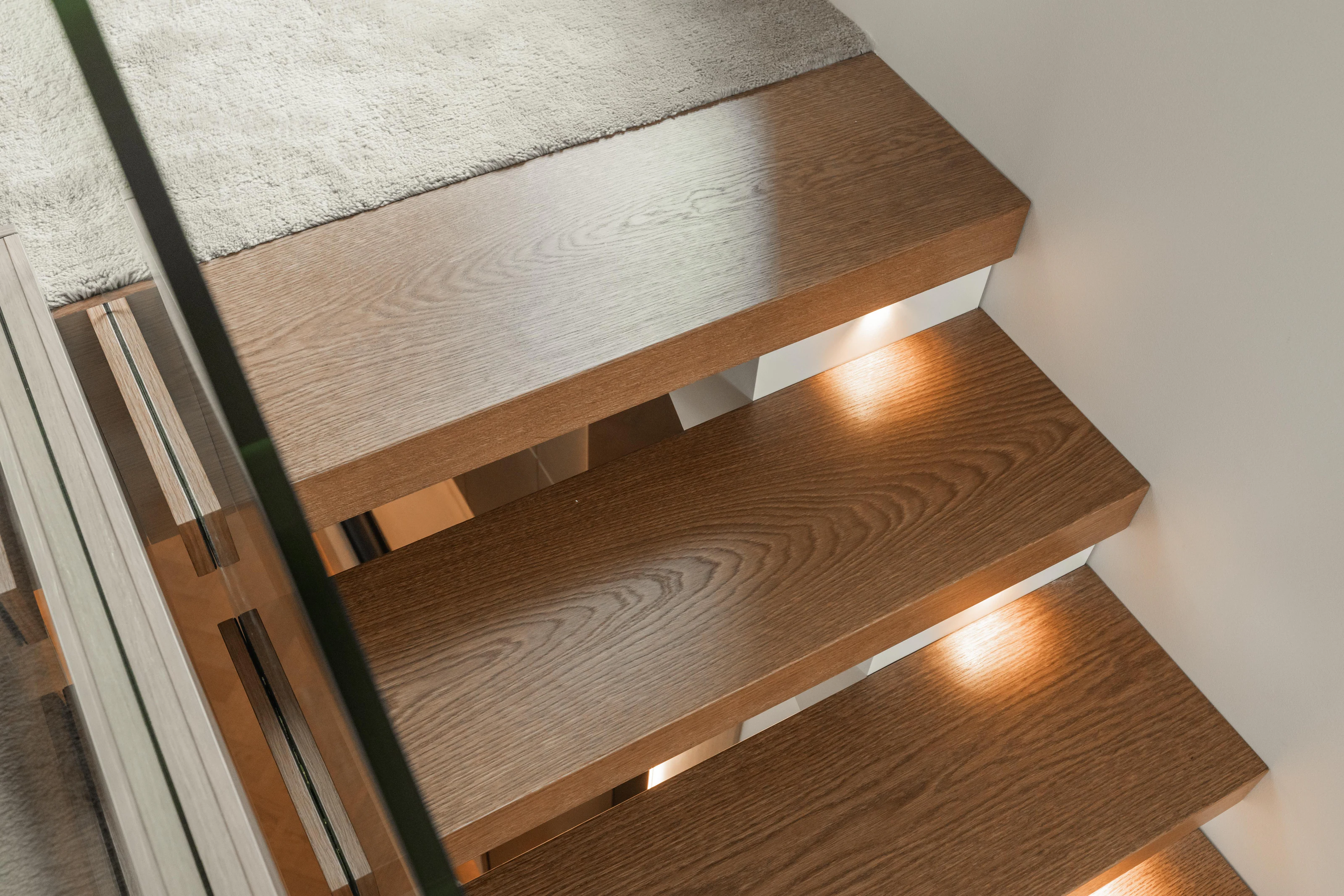 Close-up of floating oak staircase treads and integrated lighting