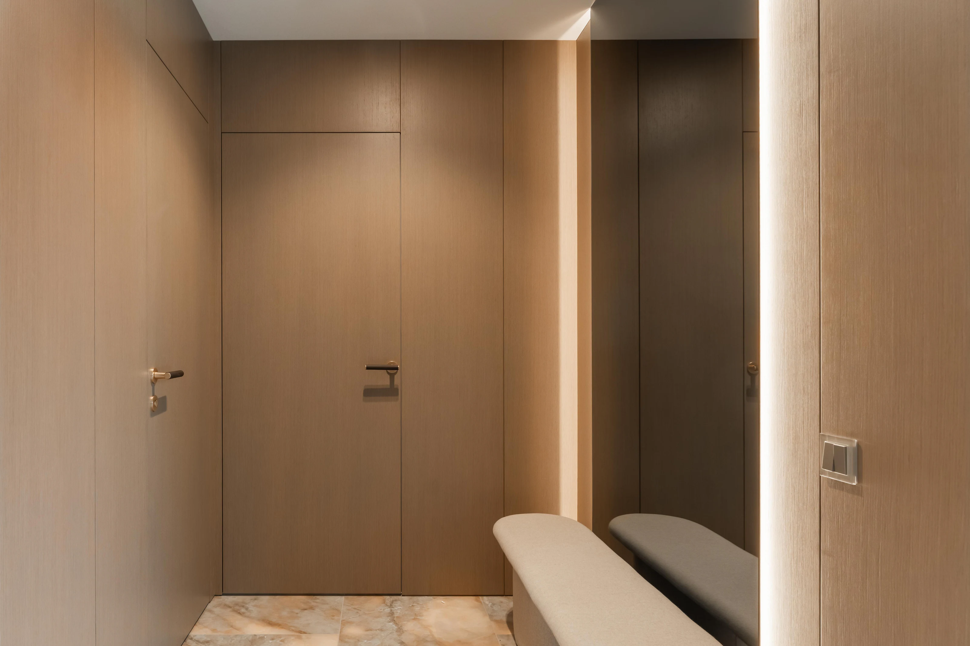 Flush oak doors integrated into a minimal hallway